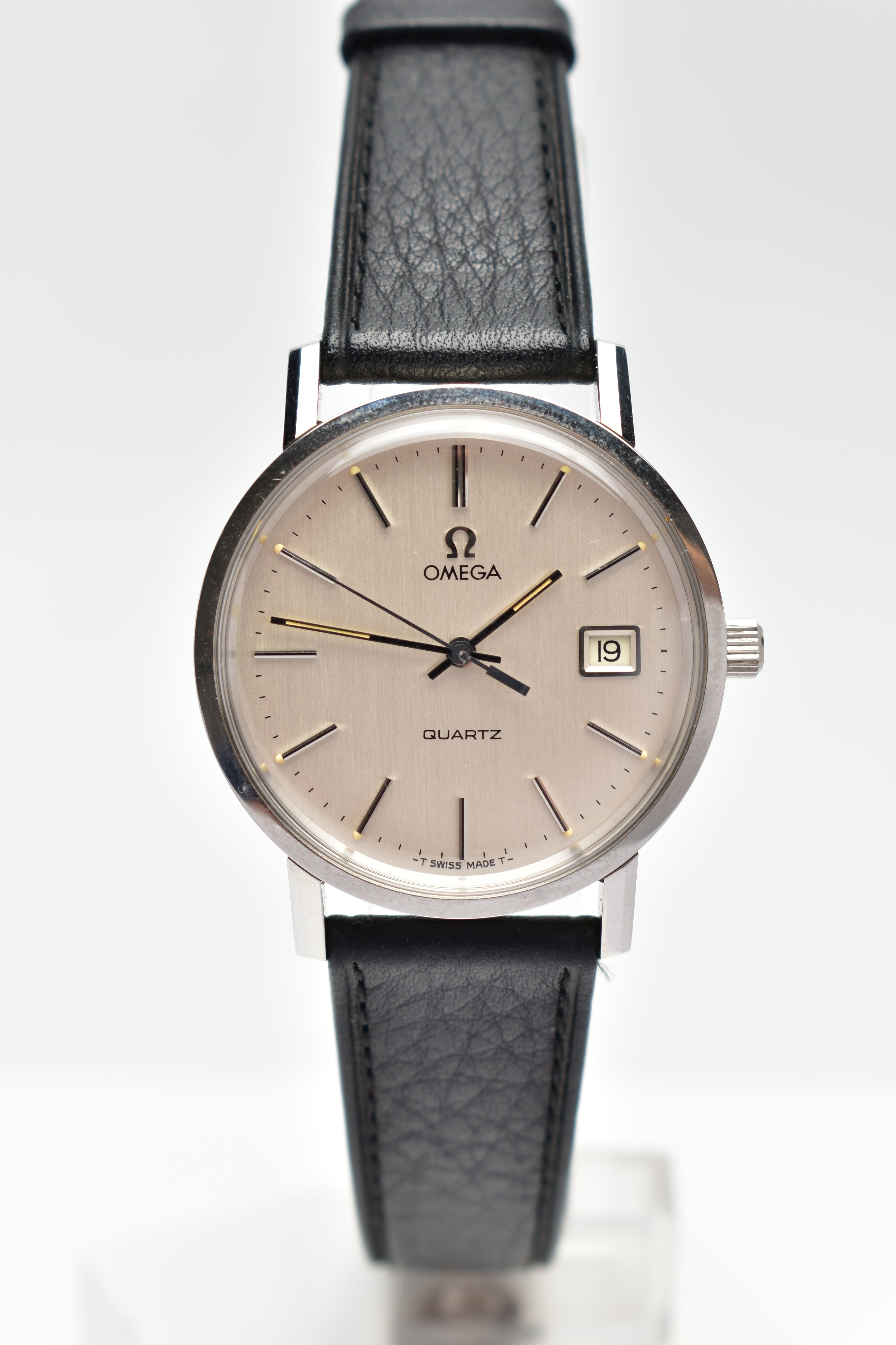 A GENTLEMANS OMEGA WRISTWATCH, the circular champagne dial, with baton hourly markers, date window