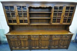 A LARGE REPPRODUCTION SOLID OAK DRESSER, the top with four glazed doors, flanking a central