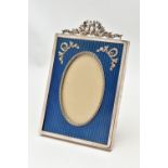 A SILVER GARLAND PHOTOFRAME, of a rectangular form, oval aperture with a deep blue patterned
