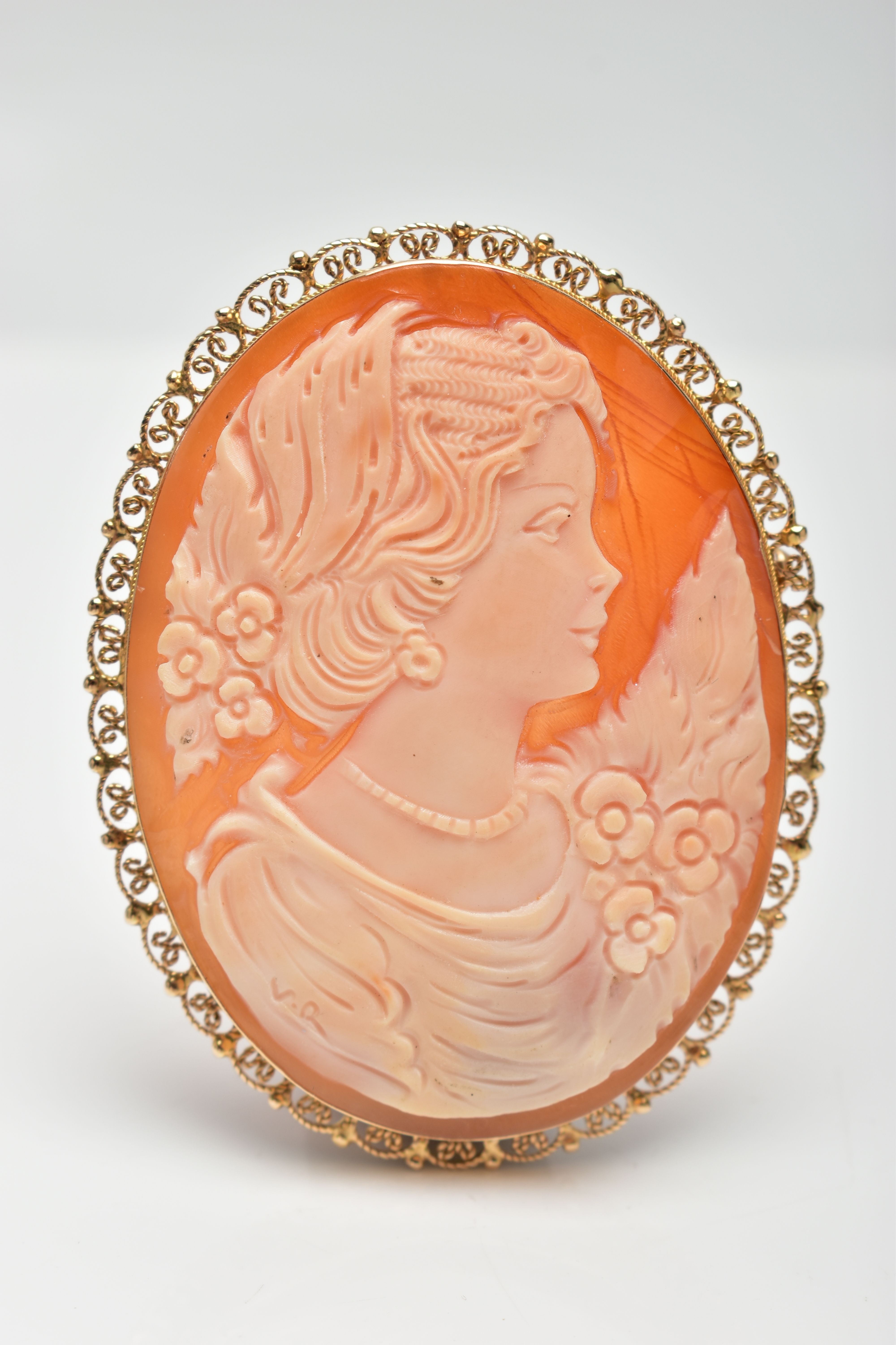 A YELLOW METAL CAMEO BROOCH, of an oval form, shell cameo depicting a lady in profile wearing a