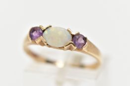 A 9CT OPAL AND CUBIC ZIRCONIA RING, centring on an oval cut opal, tension set, flanked with circular