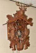 A WOODEN WALL MOUNTED CUCKOO CLOCK, German made by Regula-35, eight day movement, with a Swiss