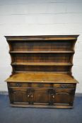 A 20TH CENTURY ELM DRESSER, the top with a two tier plate rack, base with three drawers over three