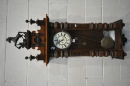 A 19TH CENTURY WALNUT CASED EIGHT DAY GUSTAV BECKER WALL CLOCK, the pediment depicting horse, two