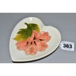A MOORCROFT POTTERY HEART SHAPED PIN DISH DECORATED WITH A CORAL HIBISCUS ON A CREAM GROUND,
