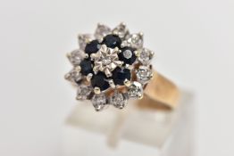 A 9CT GOLD SAPPHIRE AND DIAMOND CLUSTER RING, raised circular cluster, centering on a single cut