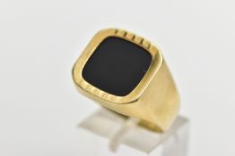 AN ONYX SIGNET RING, the square shape onyx panel, within a part textured and polished surround, to