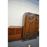 A 20TH CENTURY OAK TWO DOOR WARDROBE, the doors with a floral plaque, on bun feet, width 122cm x