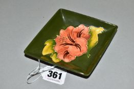 A MOORCROFT POTTERY LOZENGE SHAPED PIN DISH DECORATED WITH A CORAL HIBISCUS ON A GREEN GROUND,