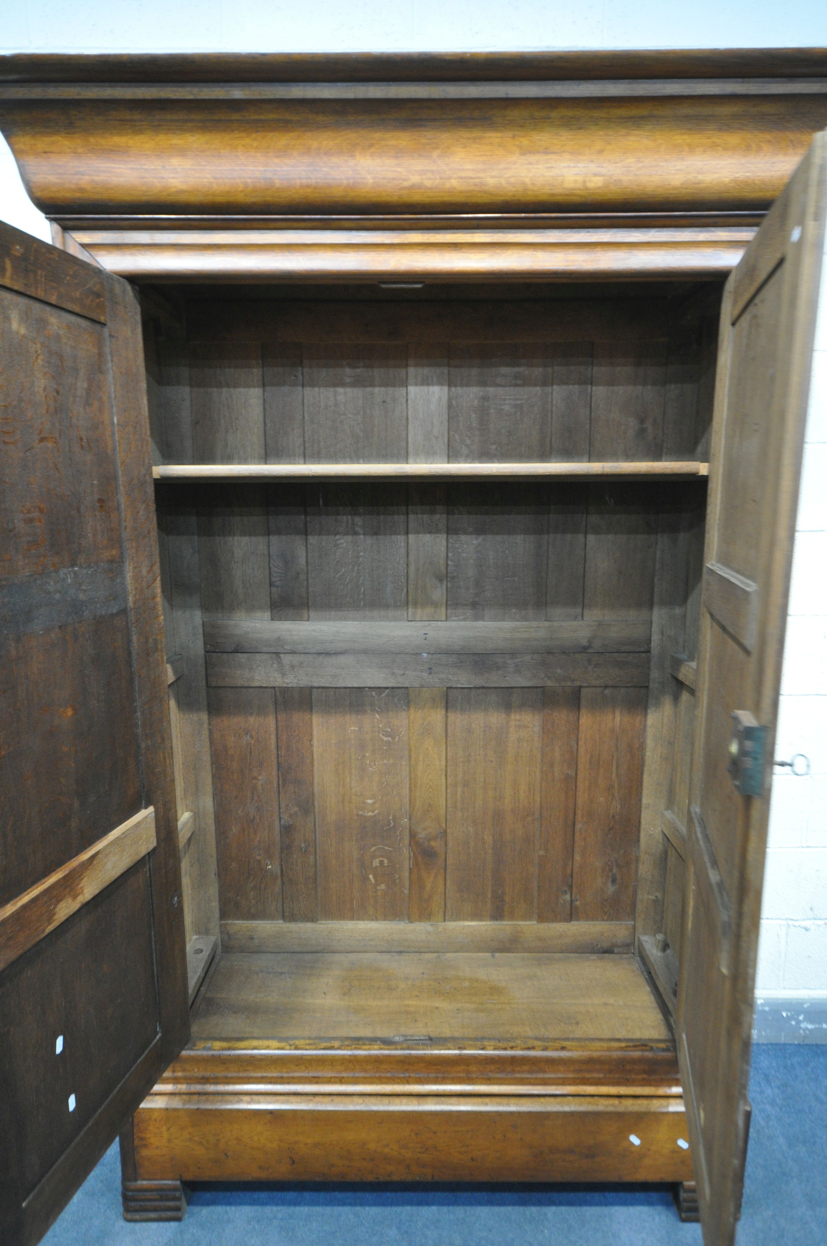 AN EARLY 20TH CENTURY OAK FRENCH ARMOIRE, the double paneled doors over a single long drawer, on Art - Image 2 of 2