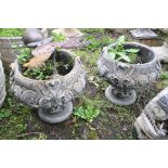 A PAIR OF COMPOSITE TWO PIECE GARDEN URNS with foliate detail to bowl and base height 33cm and a