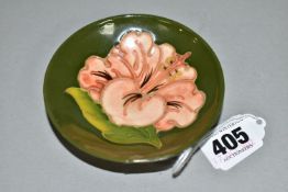 A MOORCROFT POTTERY CORAL HIBISCUS SMALL FOOTED BOWL, with Coral Hibiscus pattern on a green ground,