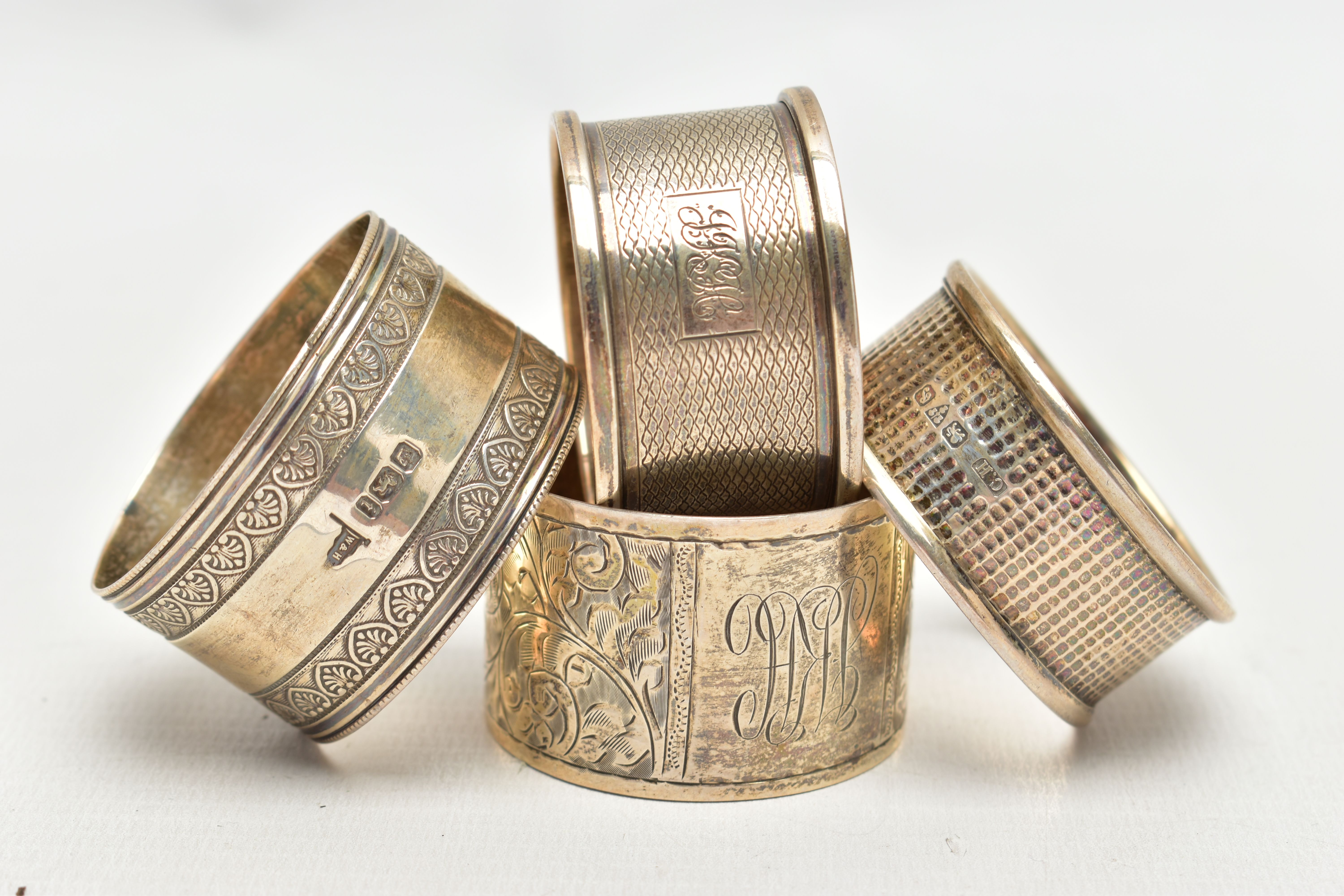 A SELECTION OF FOUR SILVER NAPKIN RINGS, to include an early 20th century Charles Horner napkin ring