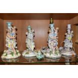 FOUR LATE 19TH CENTURY CONTINENTAL PORCELAIN FLORAL ENCRUSTED CANDLESTICKS, all modelled with a