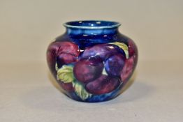 A SMALL MOORCROFT POTTERY BALUSTER VASE, decorated with tubelined purple Pansy pattern on a dark