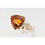 A 9CT GOLD CITRINE AND DIAMOND DRESS RING, the raised triangular cut citrine, with single cut