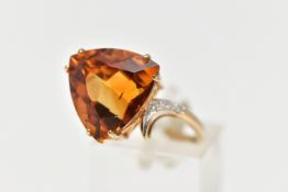 A 9CT GOLD CITRINE AND DIAMOND DRESS RING, the raised triangular cut citrine, with single cut