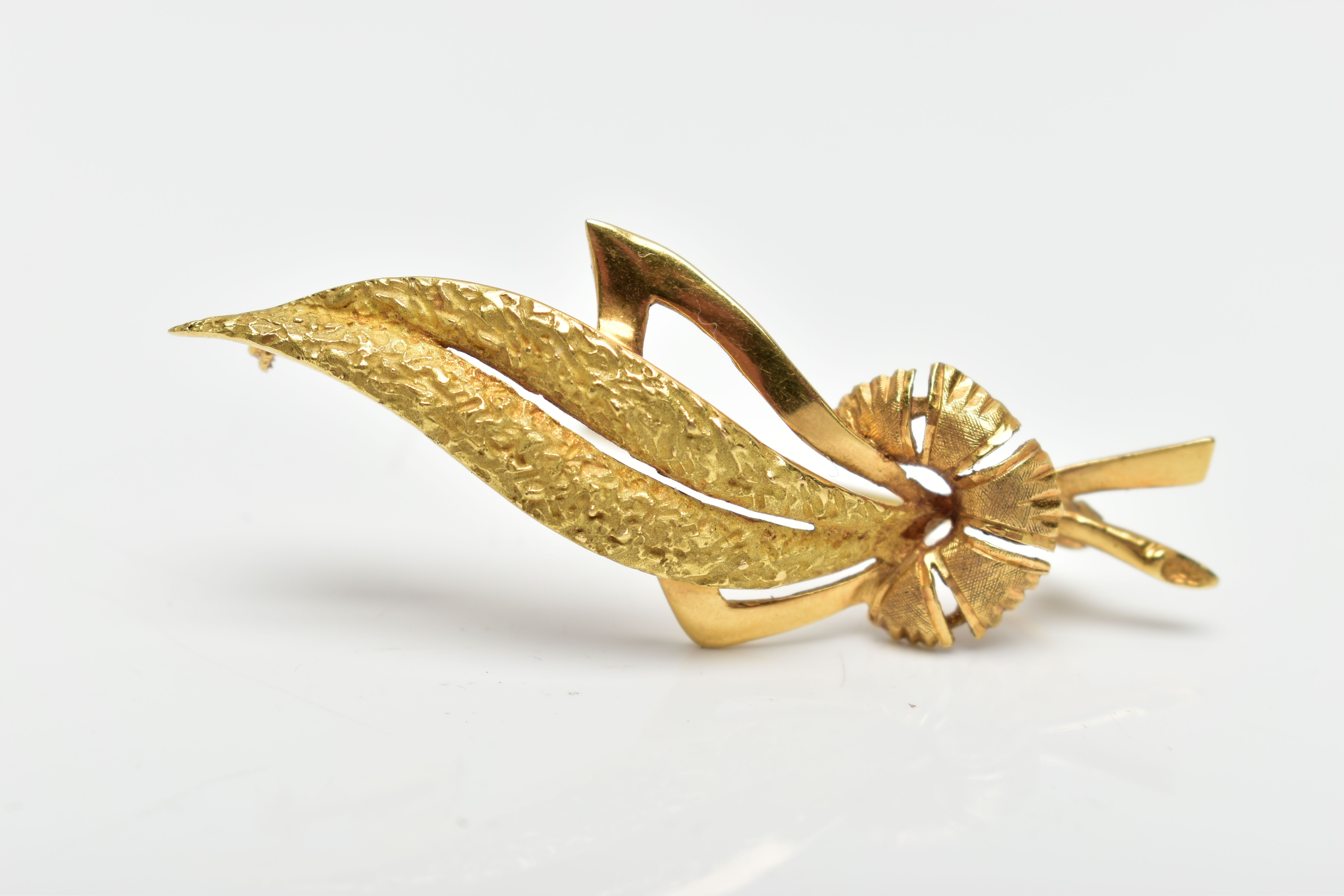 A MID 20TH CENTURY YELLOW METAL BROOCH, designed as a floral brooch with a polished and textured