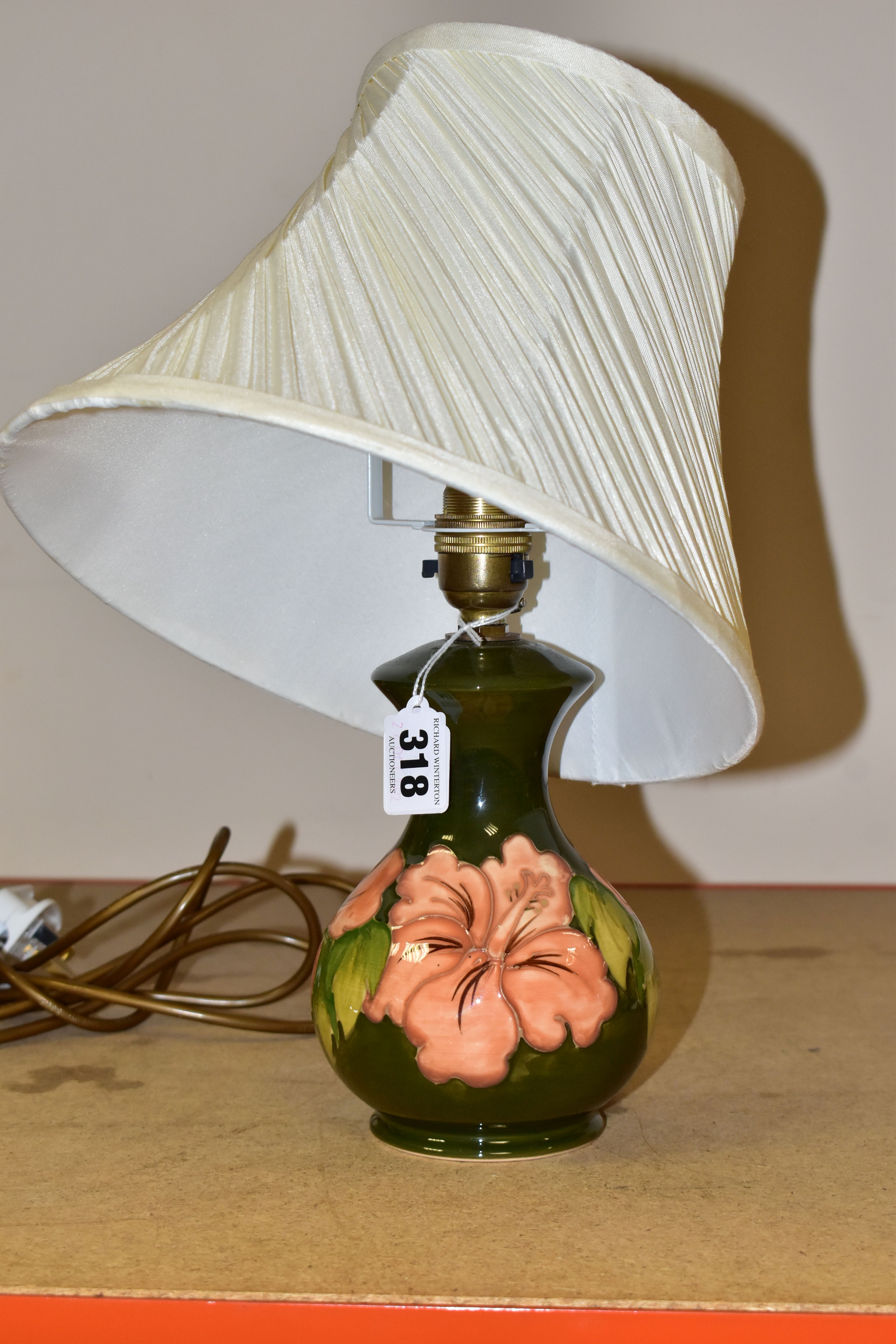 A MOORCROFT TABLE LAMP, decorated in the Coral Hibiscus pattern on a green ground with a cream