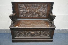 A CARVED OAK MONKS BENCH, with a hinged storage compartment, length 107cm x depth 44cm x height 73cm