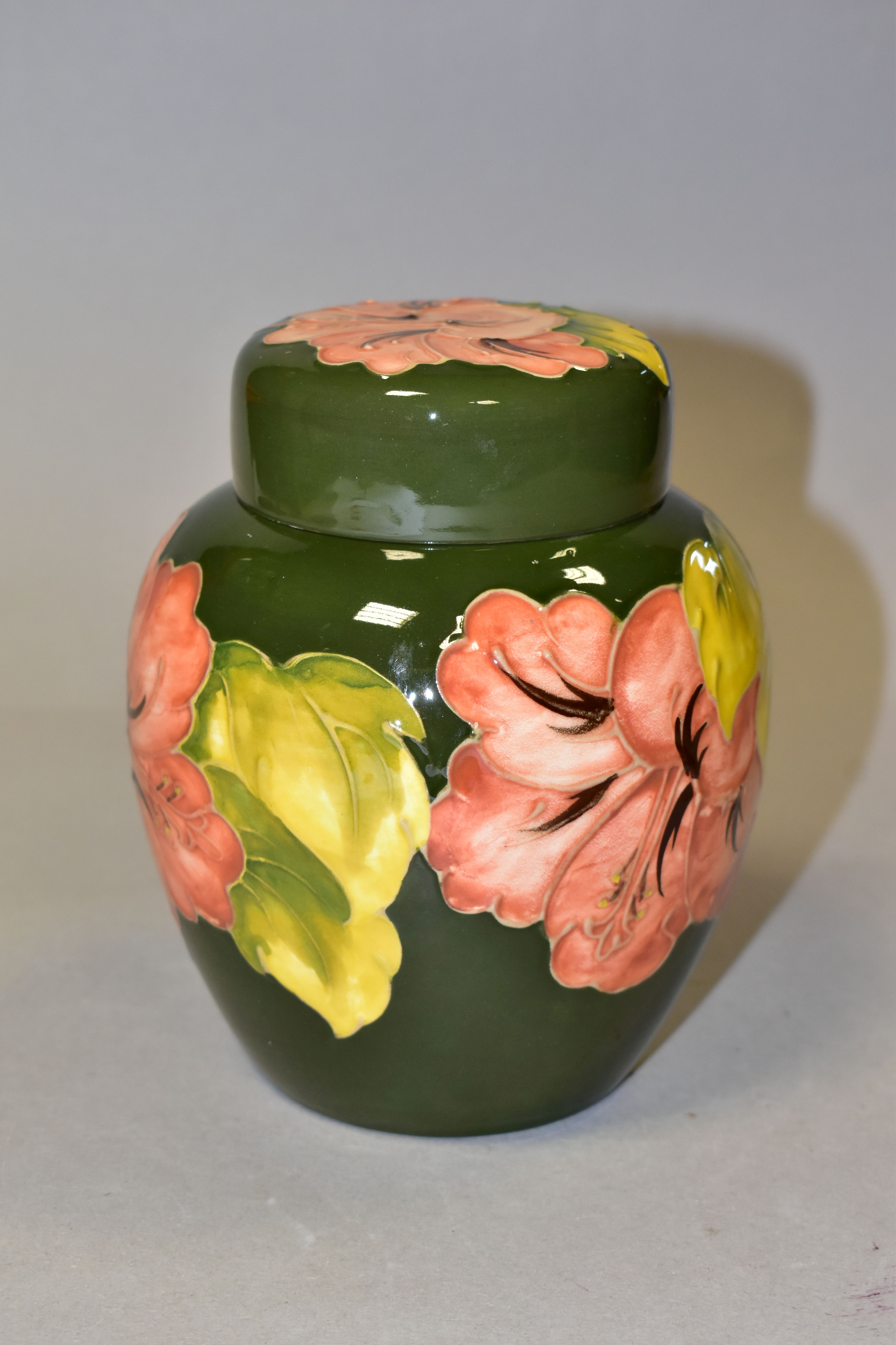 A MOORCROFT POTTERY GINGER JAR AND COVER, in the Coral Hibiscus pattern on a green ground, bears