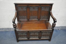 A MID 20th CENTURY OAK SETTLE with triple carved panel to base and back, foliate and fluted