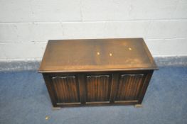 A MID 20th CENTURY OAK LINEN FOLD BLANKET BOX with triple paneled front and square pad feet, width
