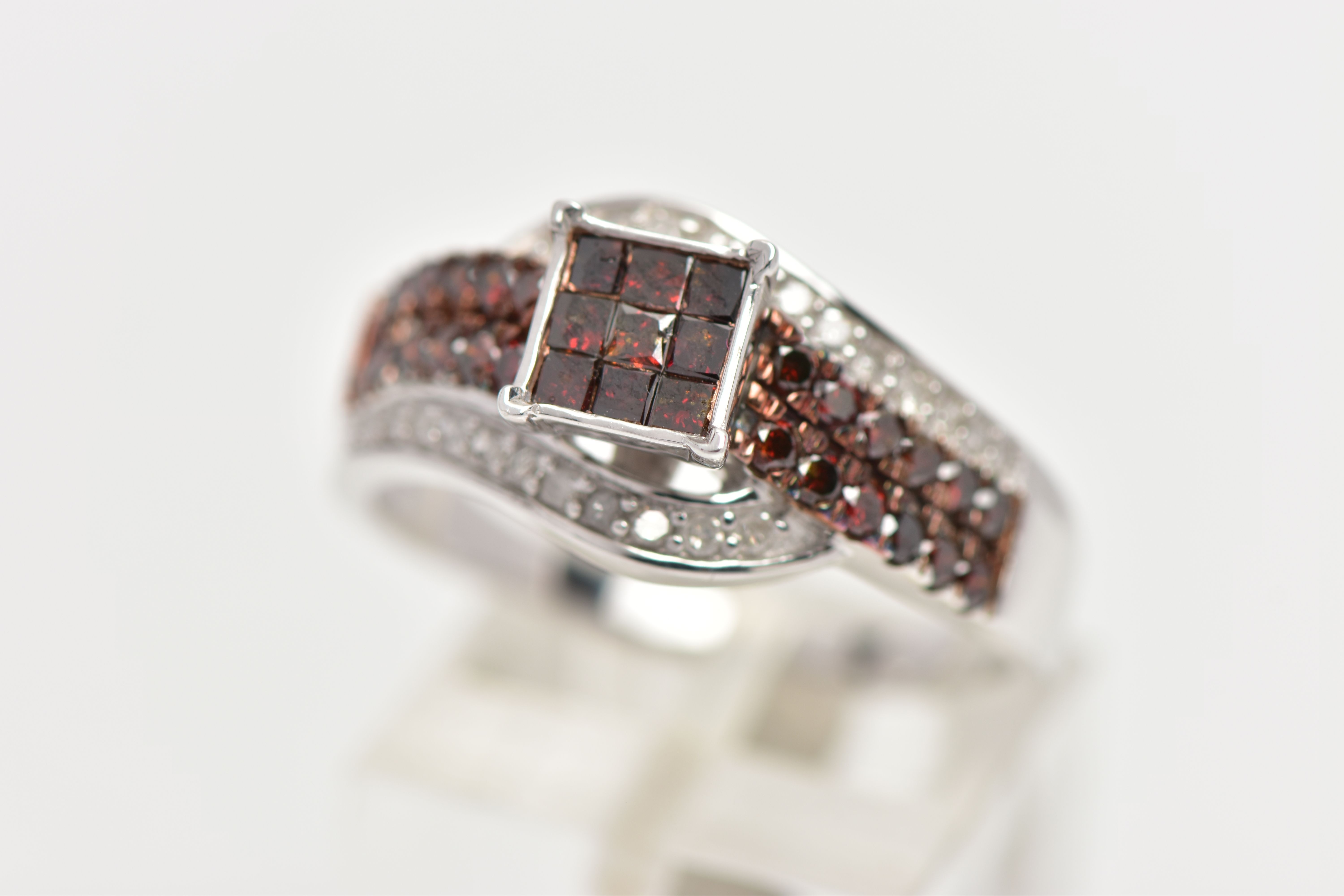 A 9CT WHITE GOLD DIAMOND DRESS RING, the calibre cut brown diamond central cluster, with brilliant