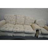 A BEIGE UPHOLSTERED THREE PIECE LOUNGE SUITE, comprising a three seater sofa and a pair of armchairs