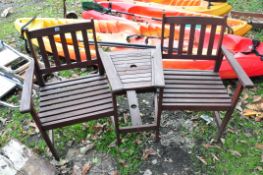 A MODERN HARDWOOD GARDEN SEAT with two chairs separated by an angled shelf and parasol hole width