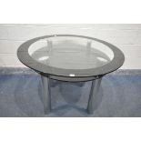 A GLASS CIRCULAR DINING TABLE, on chrome legs, with a smaller glass undershelf, diameter 110cm x