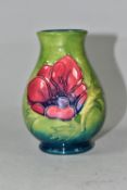 A SMALL MOORCROFT POTTERY BALUSTER VASE, tube lined in Anemone pattern on a graduated green