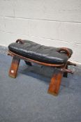 AN INDIAN HARDWOOD AND BRASS INLAID CAMEL STOOL, with a leather cushion