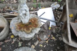 A COMPOSITE BIRD BATH in the form of a mythical figure playing pan pipes sat on an oyster shell