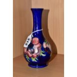 A MOORCROFT POTTERY BUD VASE, tube lined pink and purple Anemone pattern on a blue ground, impressed