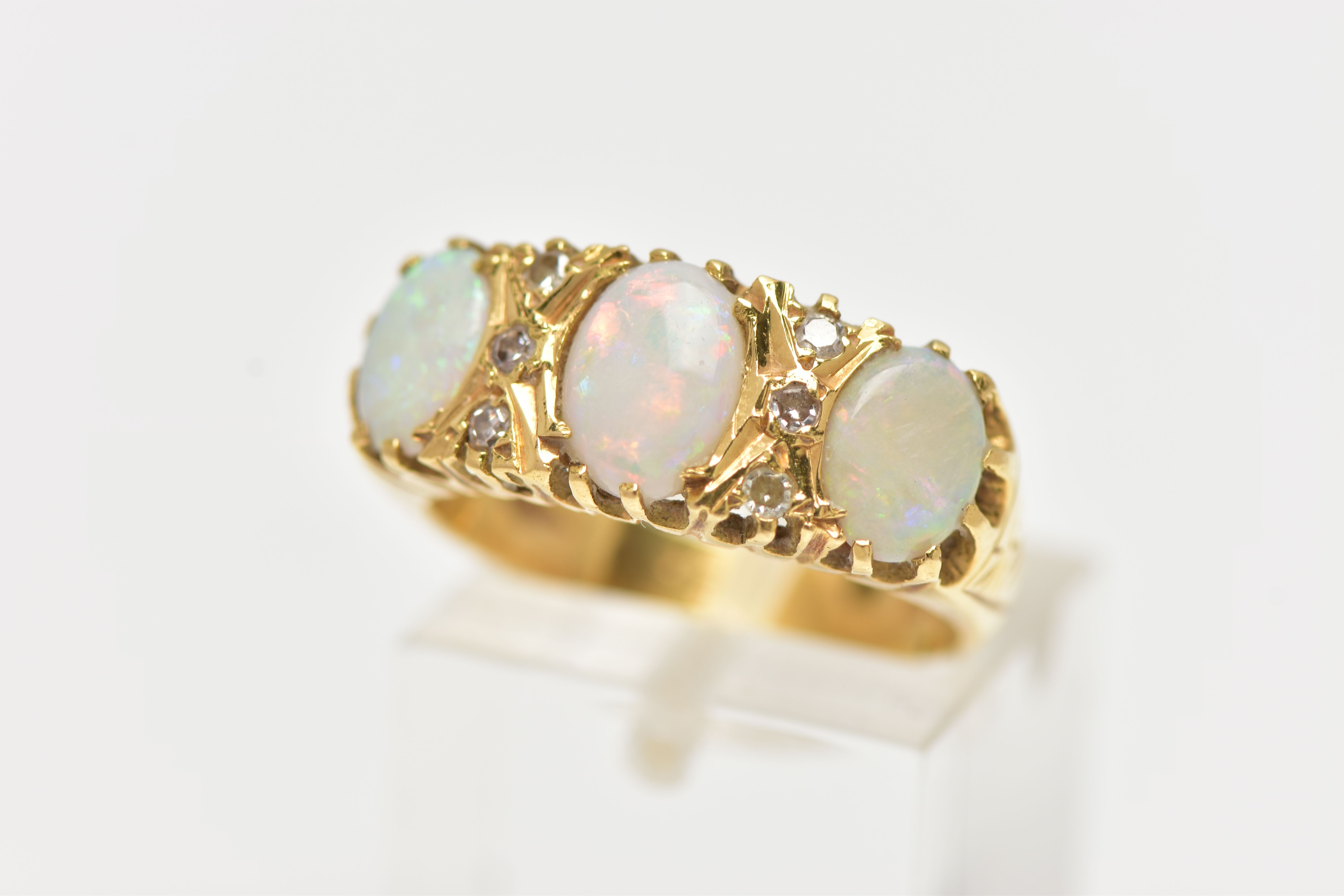 AN OPAL AND DIAMOND RING, set with three oval opal cabochons, interspaced by six single cut