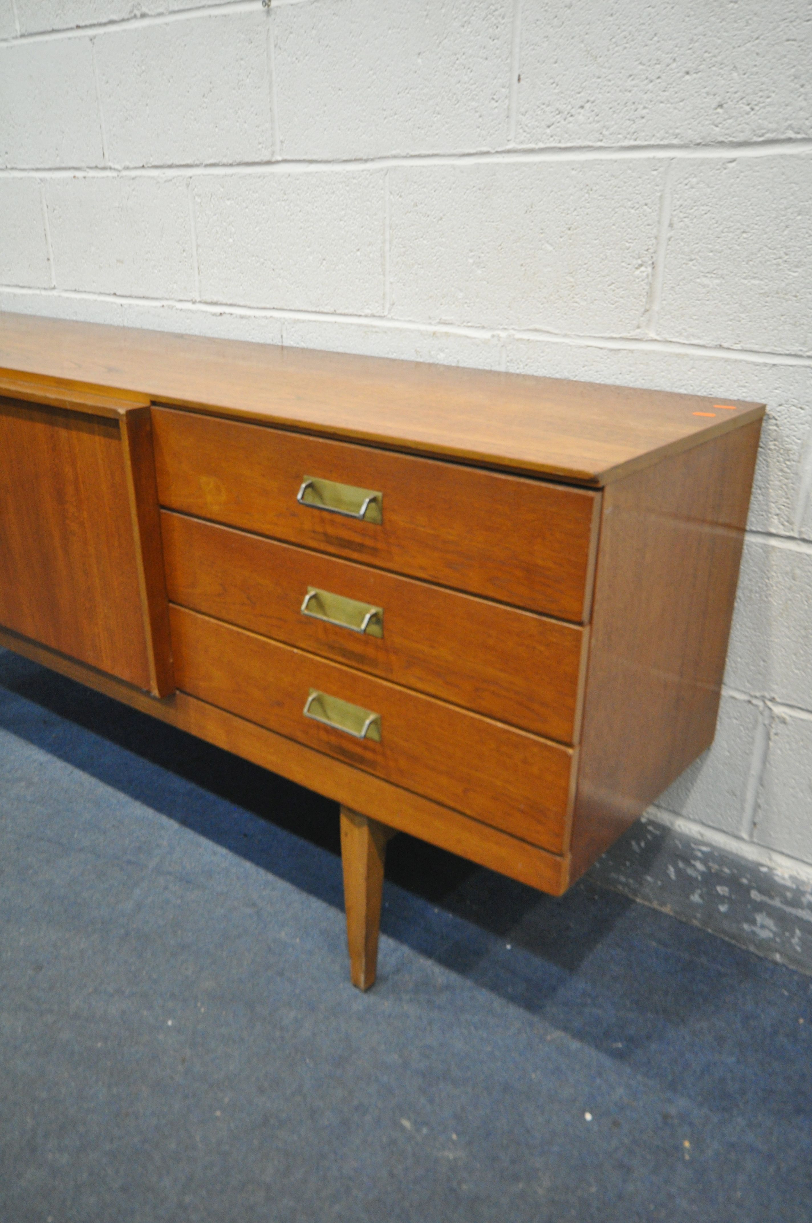 A MID CENTURY TEAK BEAUTILITY SIDEBOARD, with three drawers, two cupboard doors, flanking a pull out - Image 2 of 3