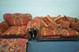 A RED FLORAL UPHOLSTERED THREE PIECE LOUNGE SUITE, comprising a three seater sofa, a wide