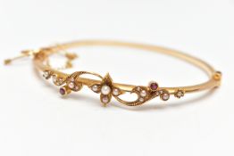 AN EARLY 20TH CENTURY 15CT GOLD BANGLE, a hinged bangle, decorated with a floral design, set with