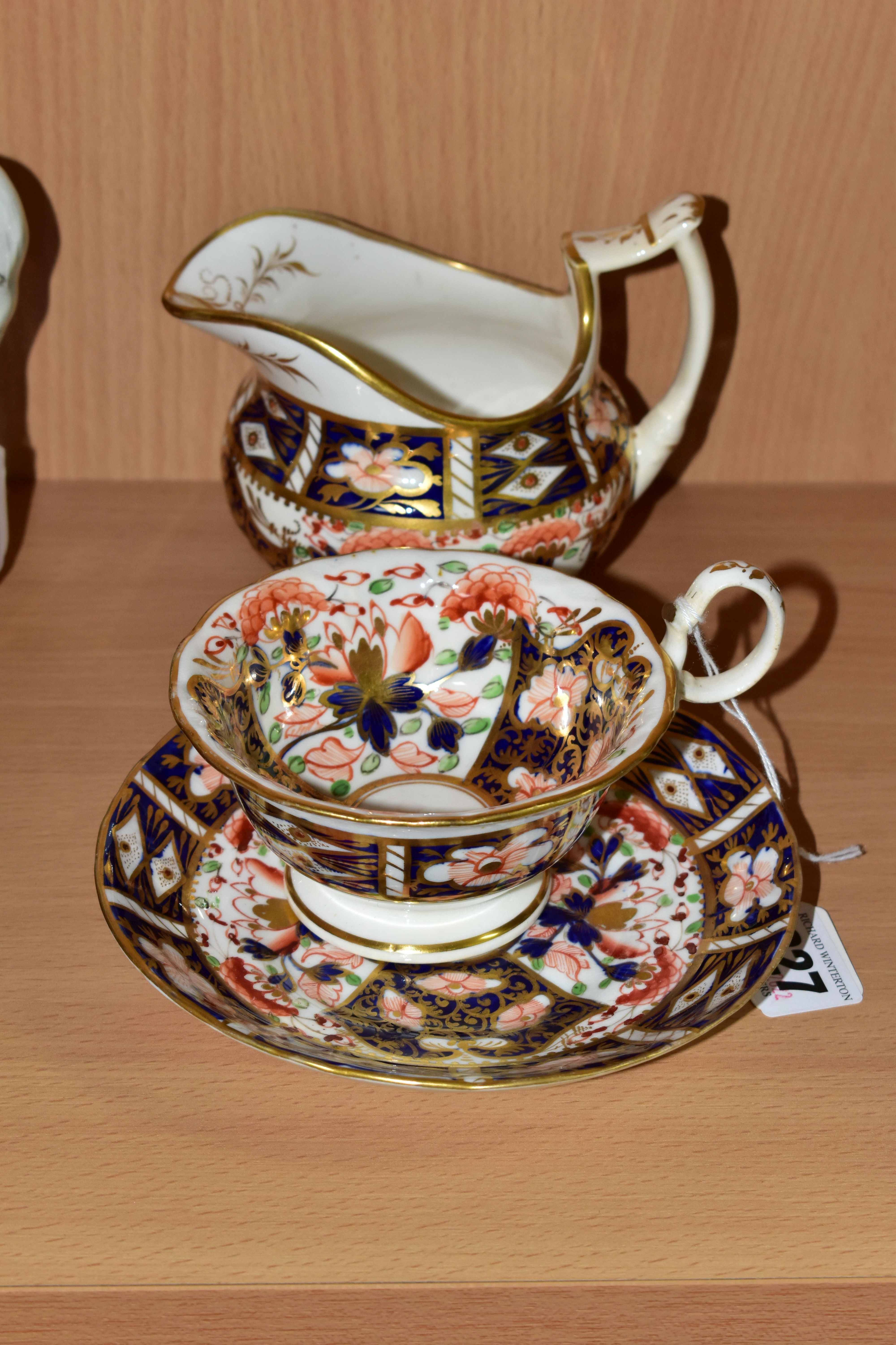 A NINETEENTH CENTURY ENGLISH TEACUP, SAUCER AND CREAM JUG, in an Imari pattern, the teacup having