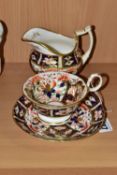 A NINETEENTH CENTURY ENGLISH TEACUP, SAUCER AND CREAM JUG, in an Imari pattern, the teacup having