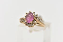 A 9CT GOLD RUBY AND DIAMOND RING, centring on an oval cut ruby, in a four claw setting, with