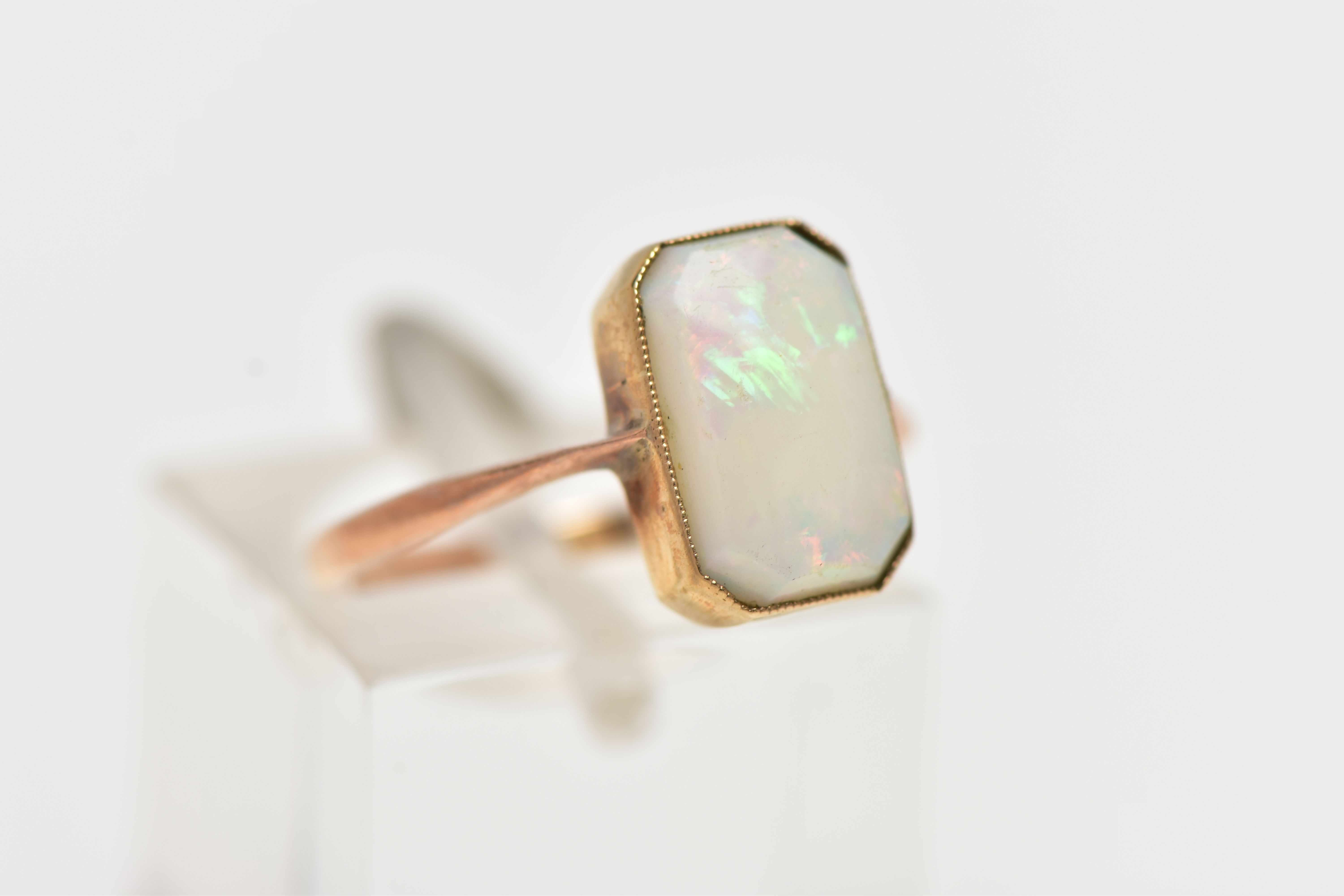 A YELLOW METAL OPAL RING, rectangular cut opal cabochon with cut off corners, milgrain collet mount, - Image 4 of 4