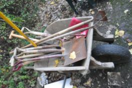 A WOODEN WHEEL BARROW and a quantity of garden tools, spades, forks, rakes, hoes etc..