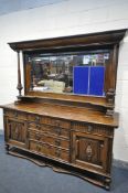 AN EARLY 20TH CENTURY OAK MIRRORBACK SIDEBOARD, with an overhanging top, supported on geometric