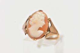 A YELLOW METAL CAMEO RING, an oval shell cameo depicting a lady facing to the right, prong set in