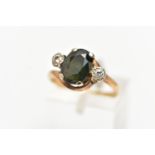 A YELLOW METAL SAPPHIRE AND DIAMOND RING, centering on an oval cut bluish/green sapphire in a four