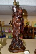 A LARGE WOODEN FIGURAL TABLE LAMP, a hand carved figure of Chinese Shou Lao (god of Longevity),