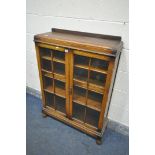 AN OAK TWO DOOR BOOKCASE, with three adjustable shelves, width 85cm x depth 28cm x height 128cm (