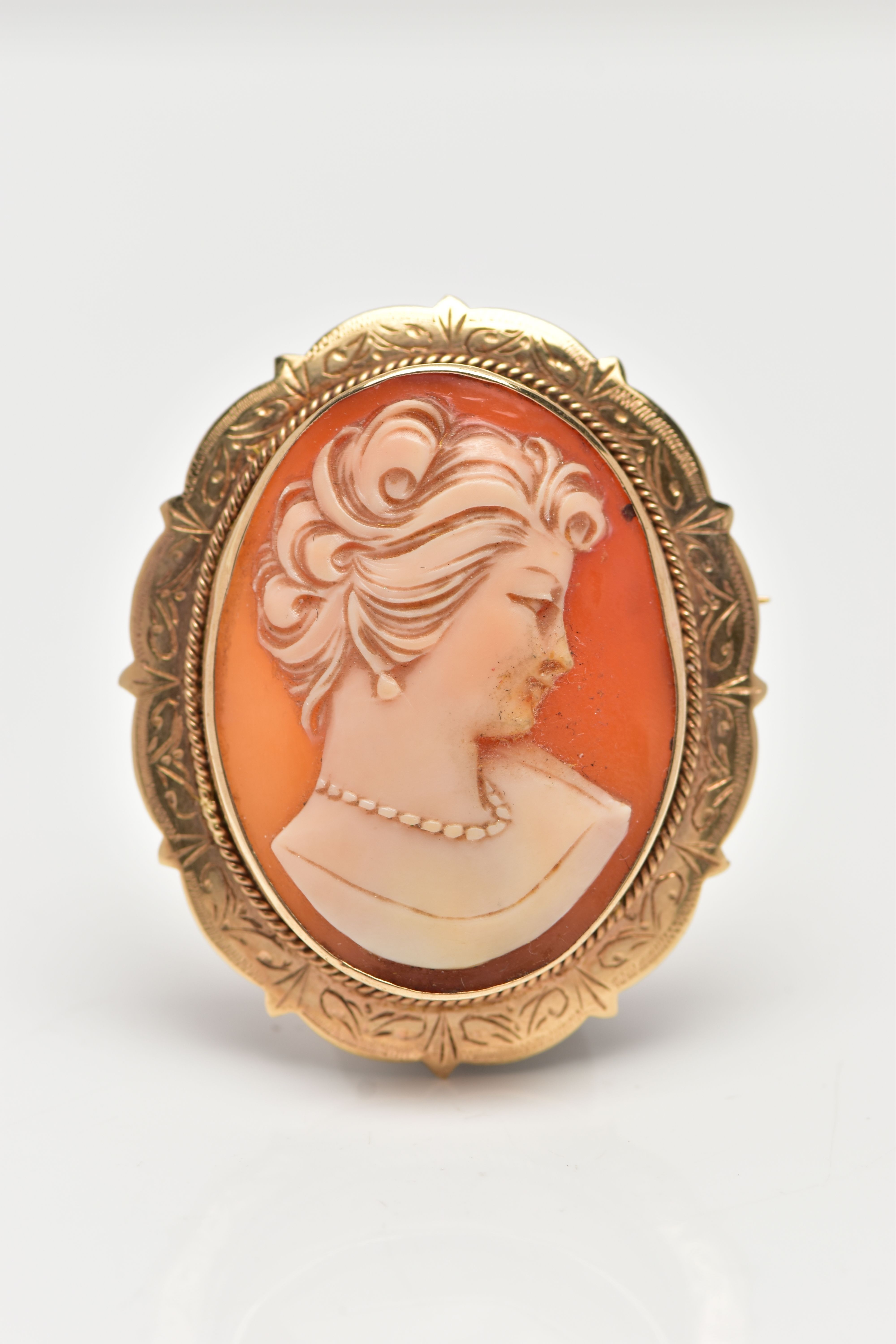 A 9CT GOLD SHELL CAMEO BROOCH/PENDANT, of an oval form depicting a lady in profile, collet set